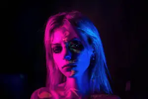 A beautiful woman dressed in purple against a dreamy purple background