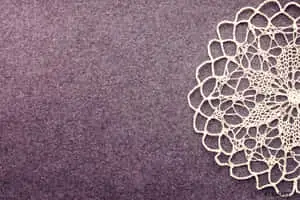 a white doily on a purple background